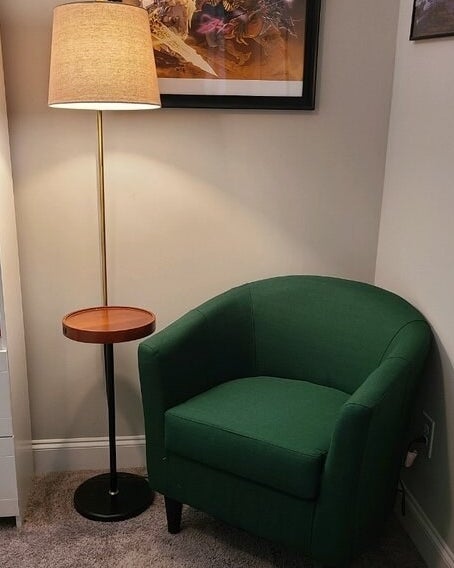 a reviewer photo of the lamp next to a green chair