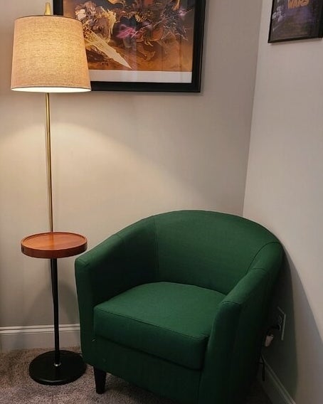 a reviewer photo of the lamp next to a green chair