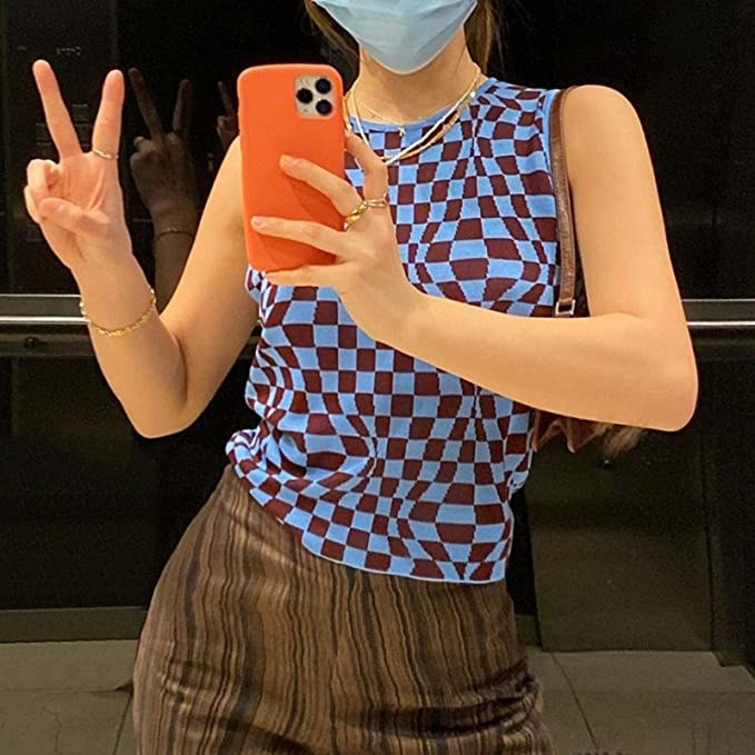 a person taking a photo of themselves in a mirror wearing the checkered knit tank top