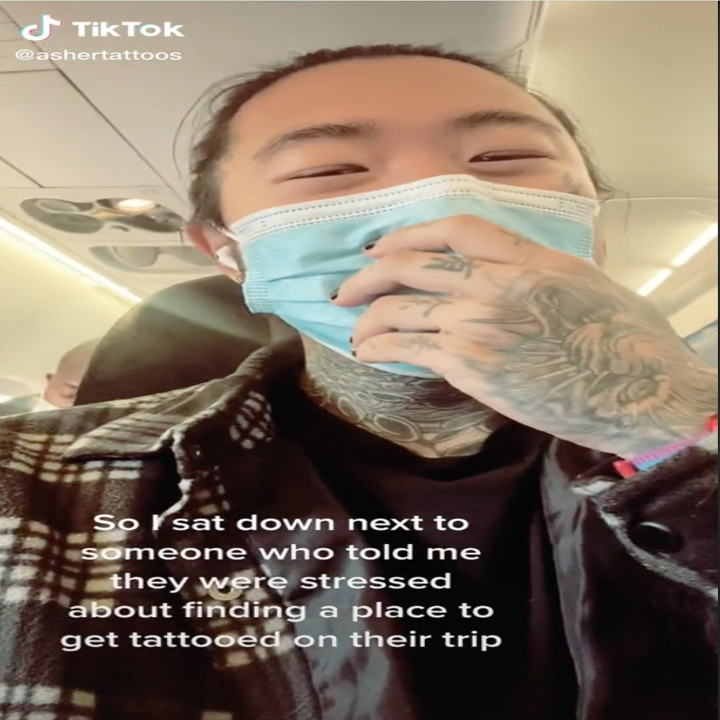 Screenshot from a video by TikTok user @luckyboytattoo on an airplane