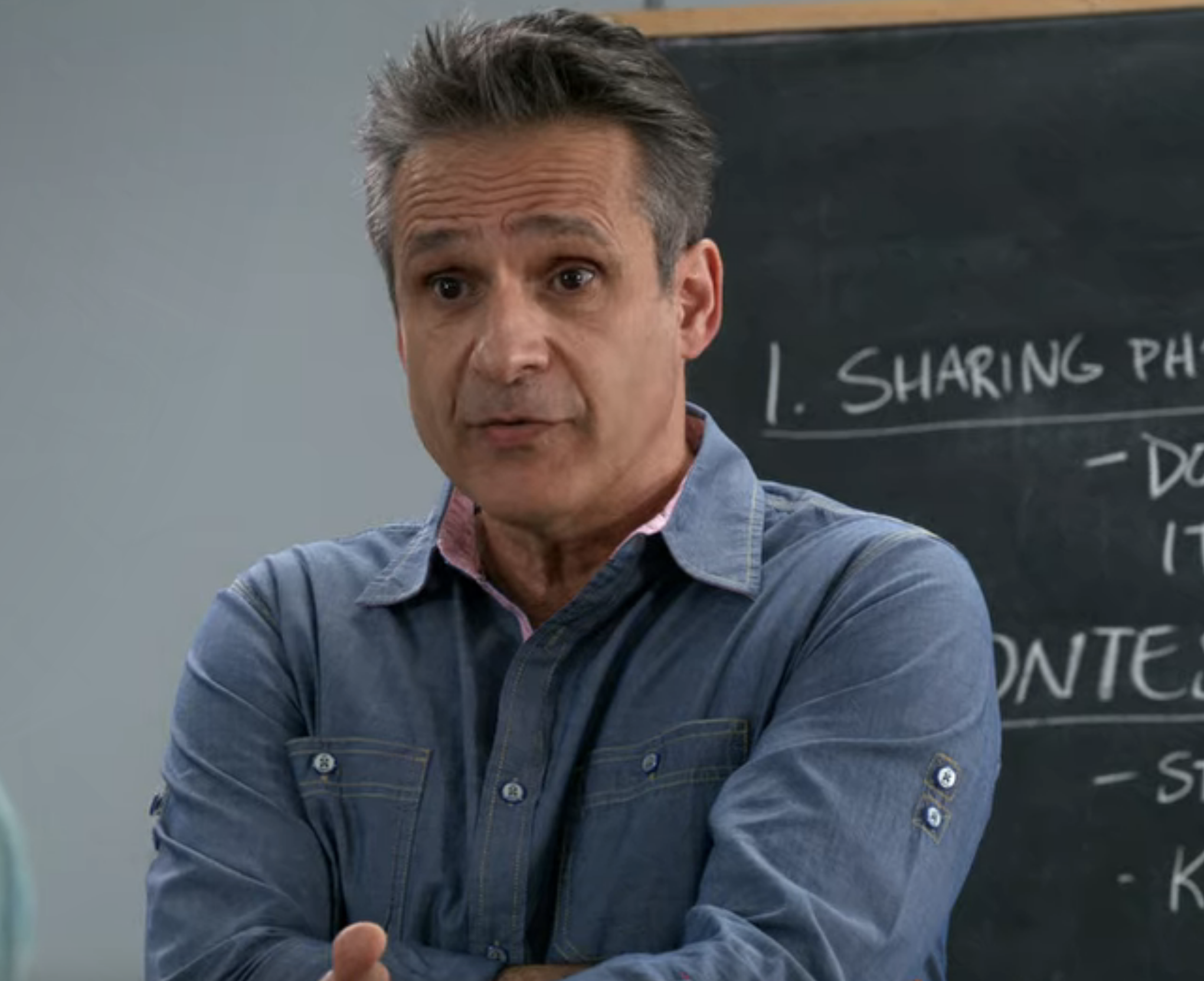 A teacher in front of a chalk board