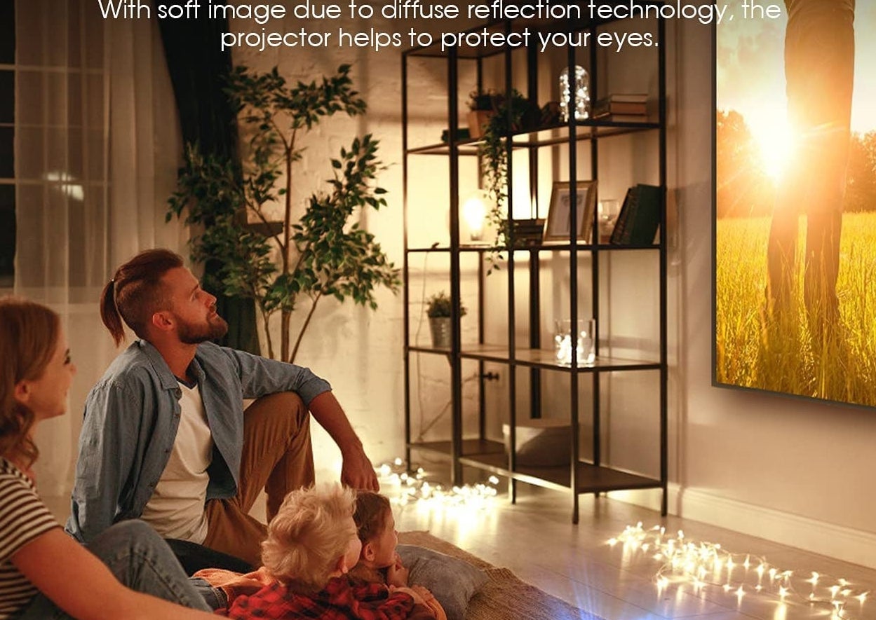 a family watching a movie in their living room from a projector on a table