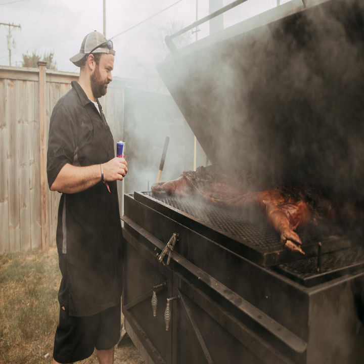 A man cooking at the BBQ pit