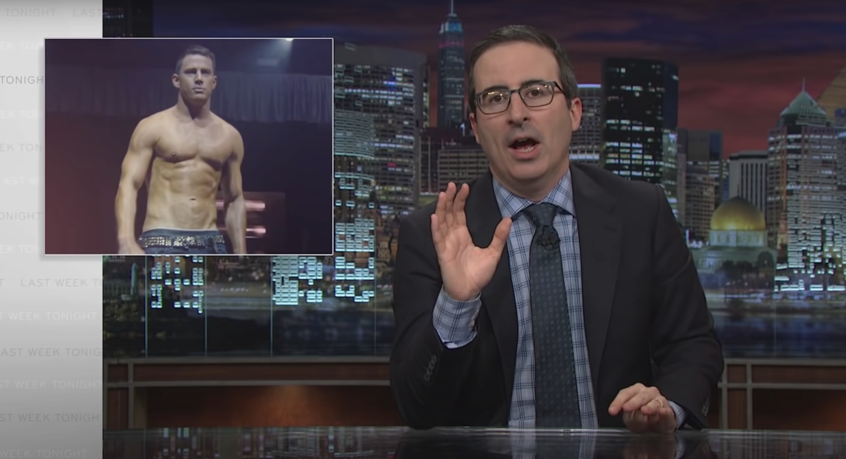 John Oliver speaking at his desk with an image of Channing Tatum shirtless in Magic Mike next to him