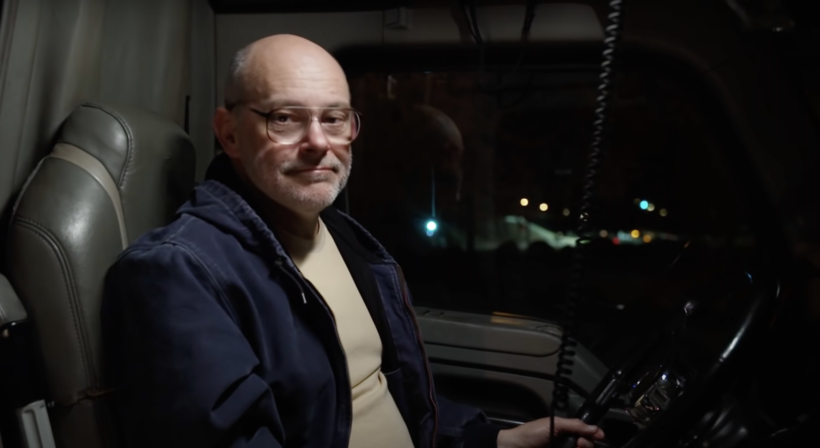 Rob Corddry sitting in a truck, looking at the camera in a small smile