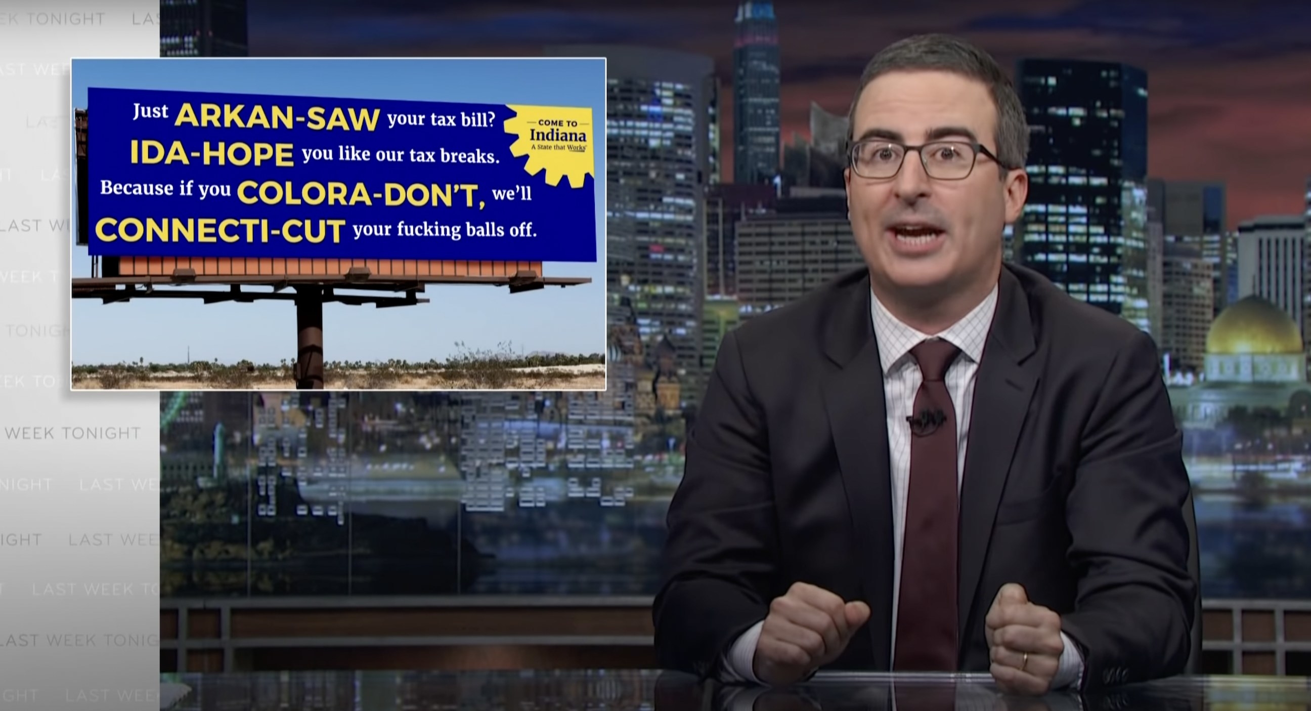 John Oliver at his desk, with an image next to him of a billboard that says, Just Arkan saw your tax bill question mark, Ida hope you like our tax breaks, because if you Colora dont, well Connecti cut your fucking balls off