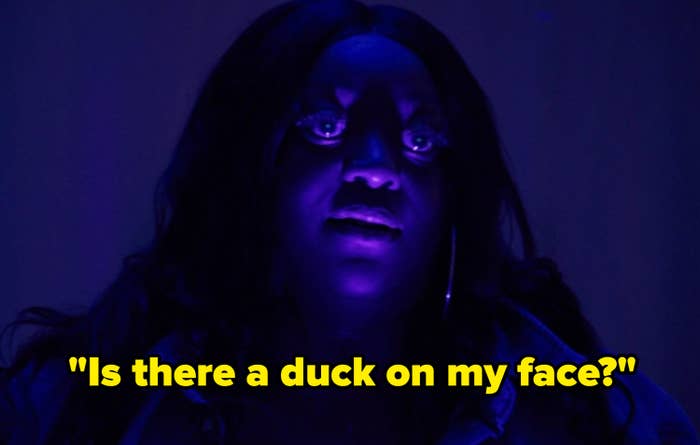 In a dark room where her fact is lit from below, Judi Love asks, Is there a duck on my face