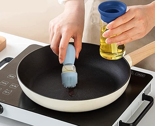 the oil dispenser being used on a frying pan