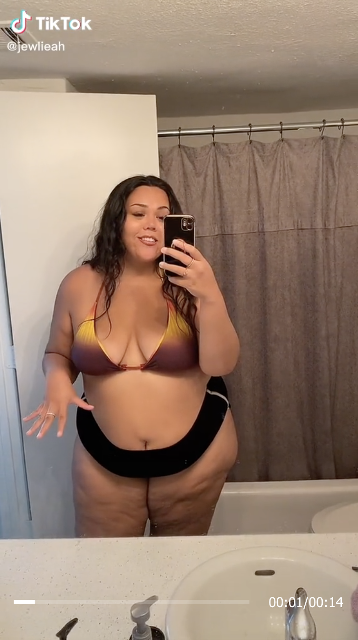 Julia wearing a bra and panties takes a selfie in front of a bathroom mirror