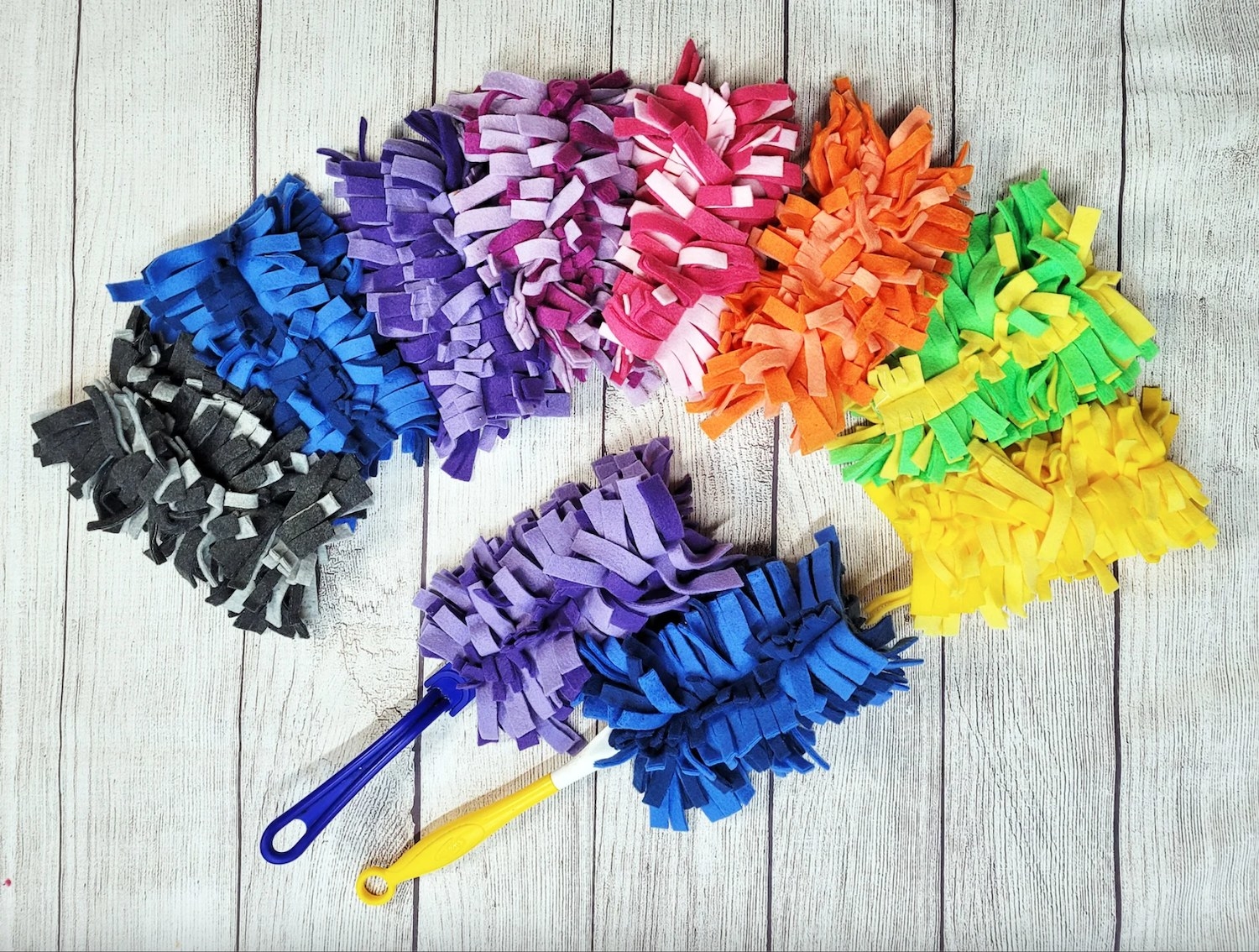 a rainbow of reusable dusters on a wooden background