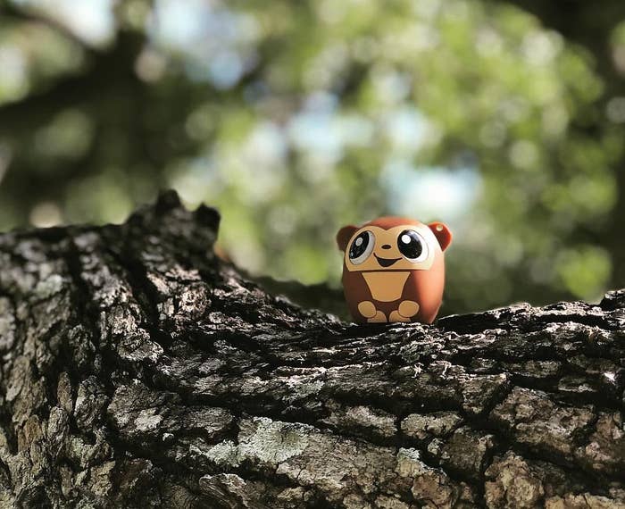 a tiny monkey-shaped speaker on a tree