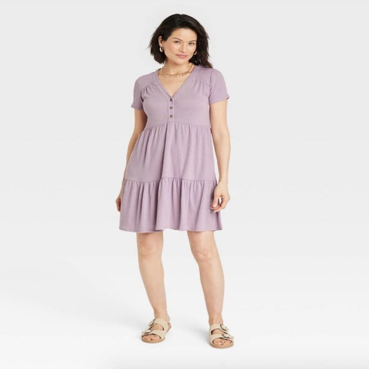 A model wearing a lilac purple dress