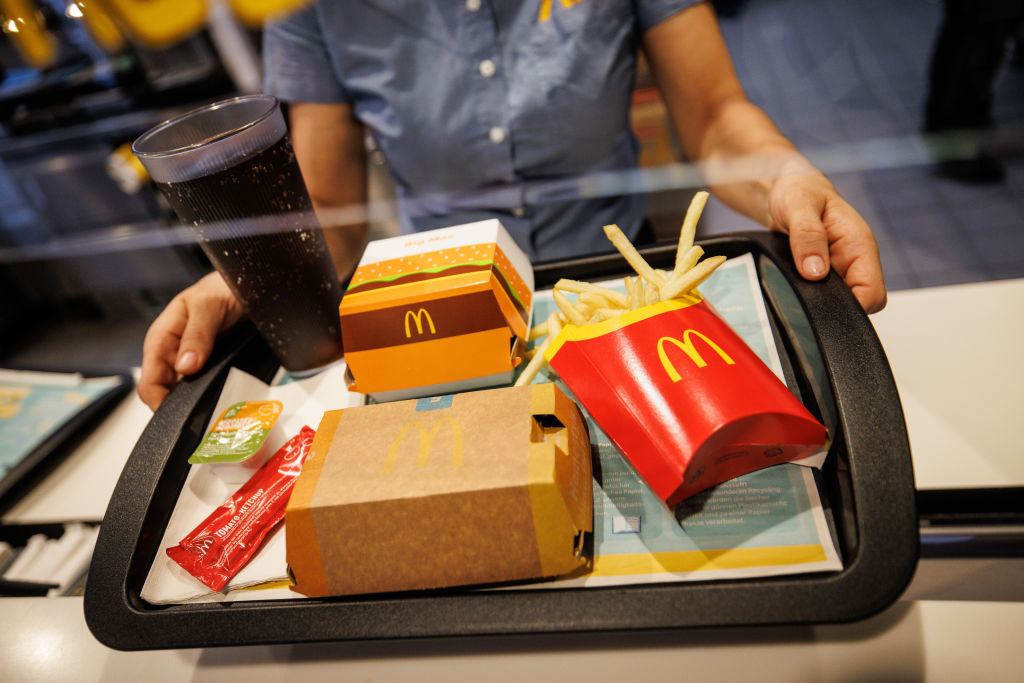 a McDonald&#x27;s employee handing out a tray