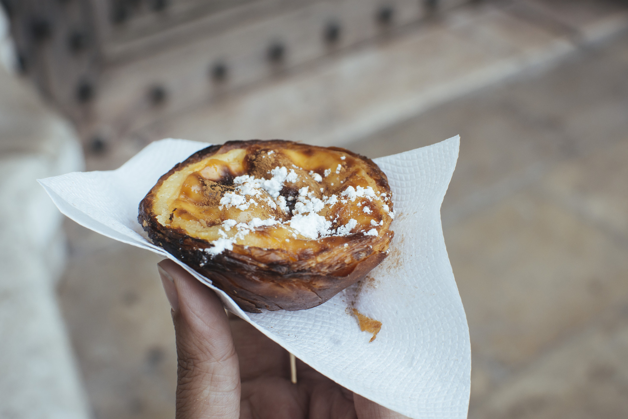 A Portuguese egg tart with sugar on top.