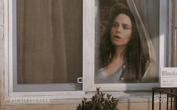 a gif of Stevie from Schitts Creek looking out the window
