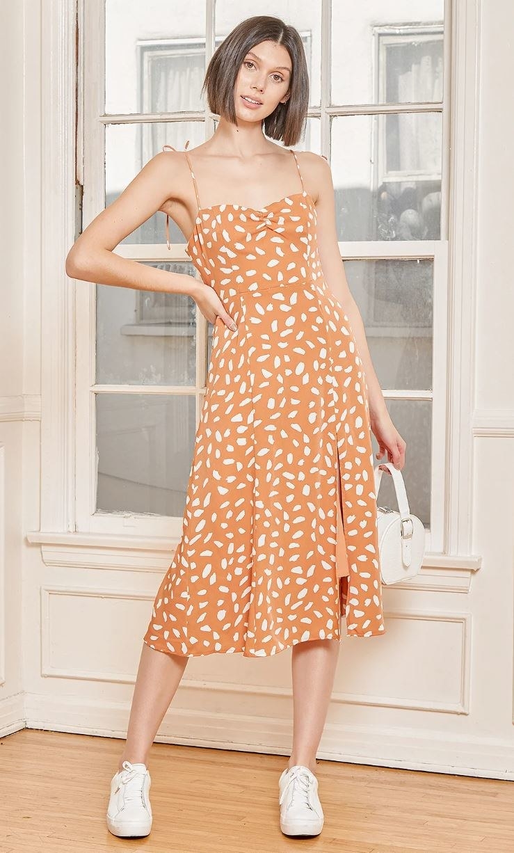 model wearing orange patterned midi dress