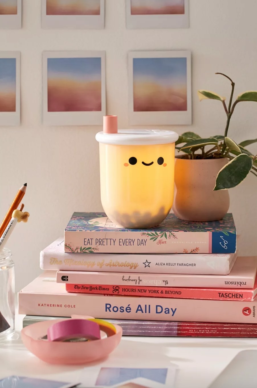 the boba shaped lamp on top of a stack of pink books
