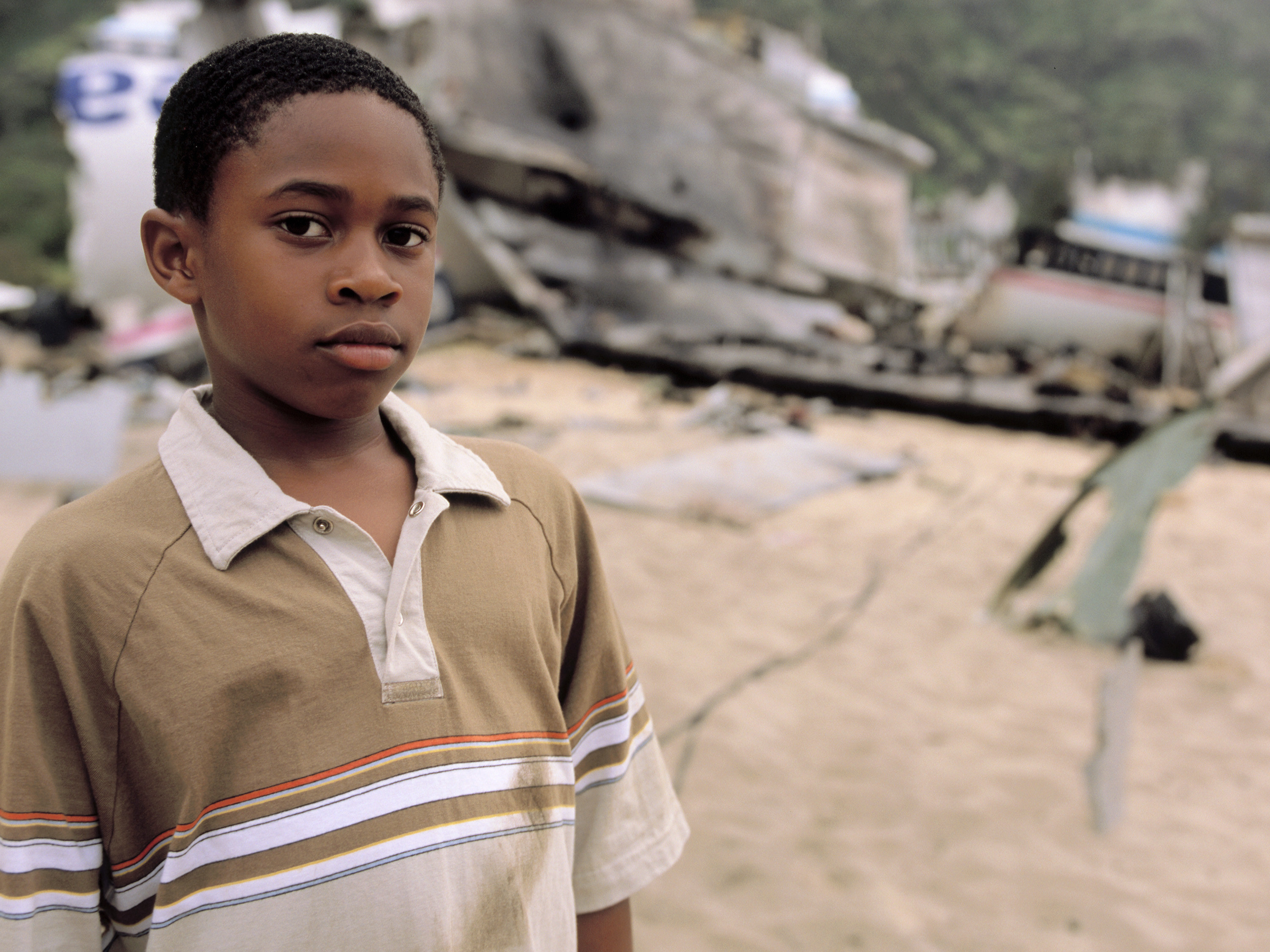 Malcolm as a child with the crashed plane in the background