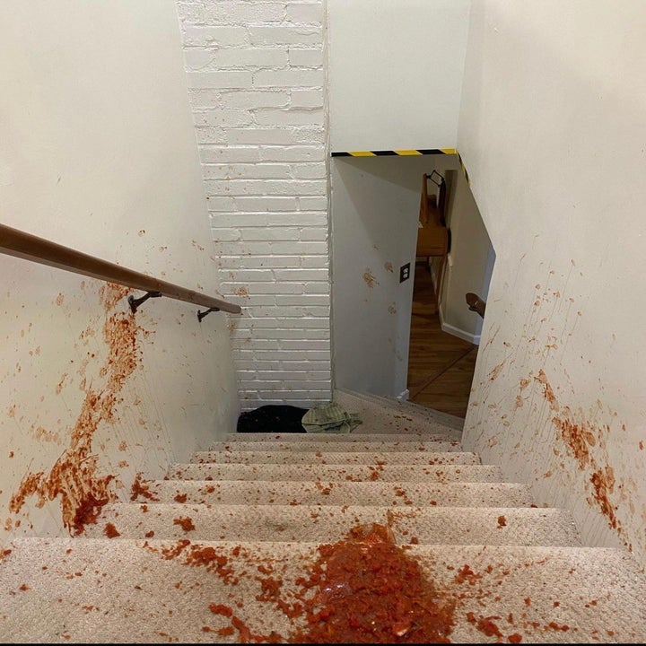 a reviewer photo of a carpeted stairwell covered in red salsa