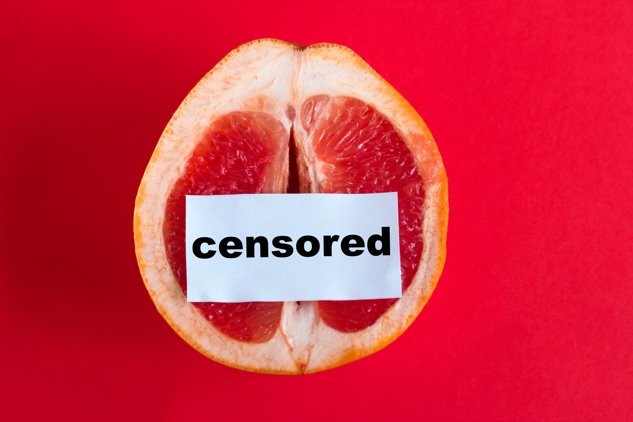 A halved grapefruit with a slip of paper with "censored" on it over it