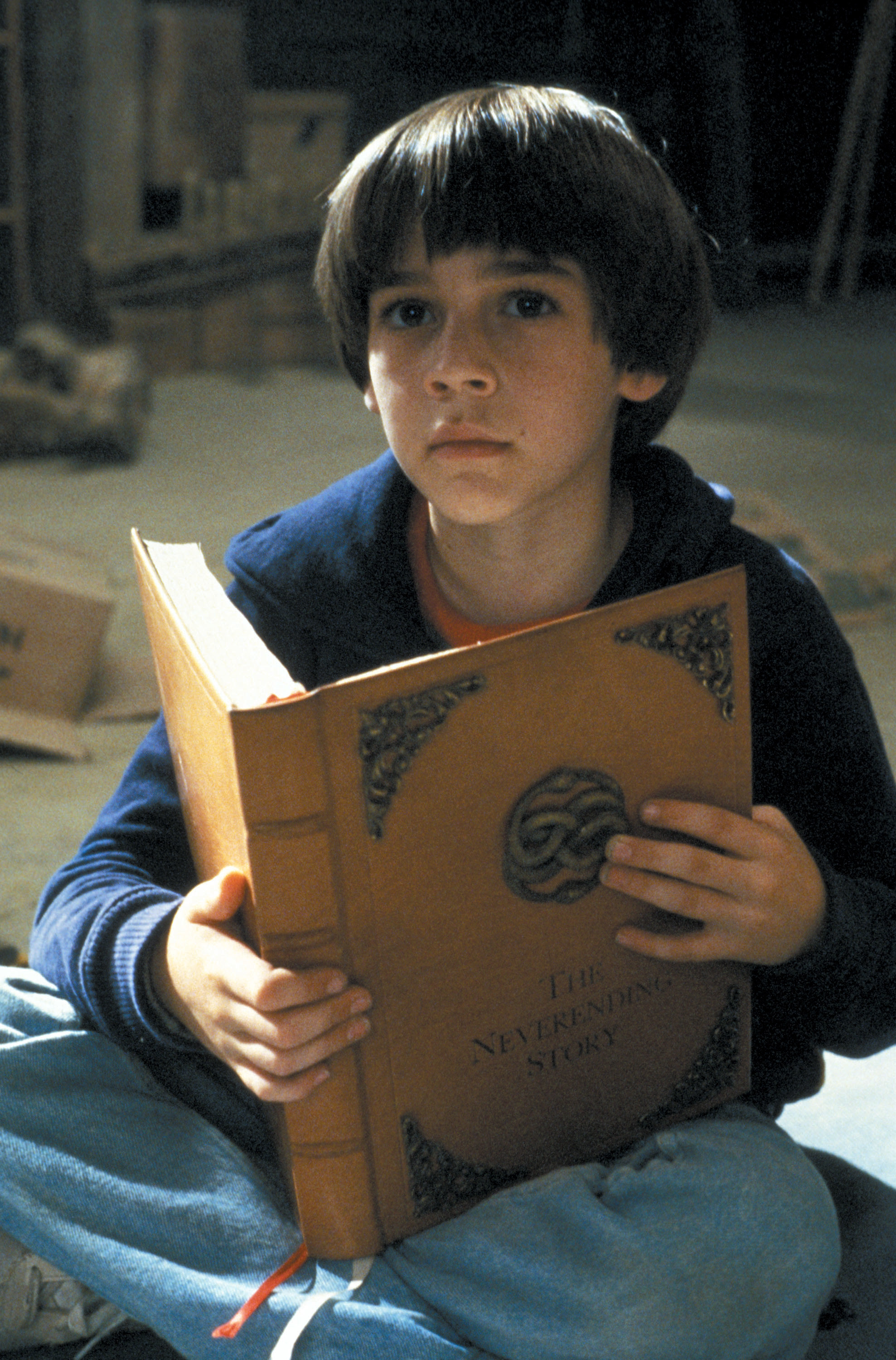 Barret as a child holding the book &quot;The Neverending Story&quot;