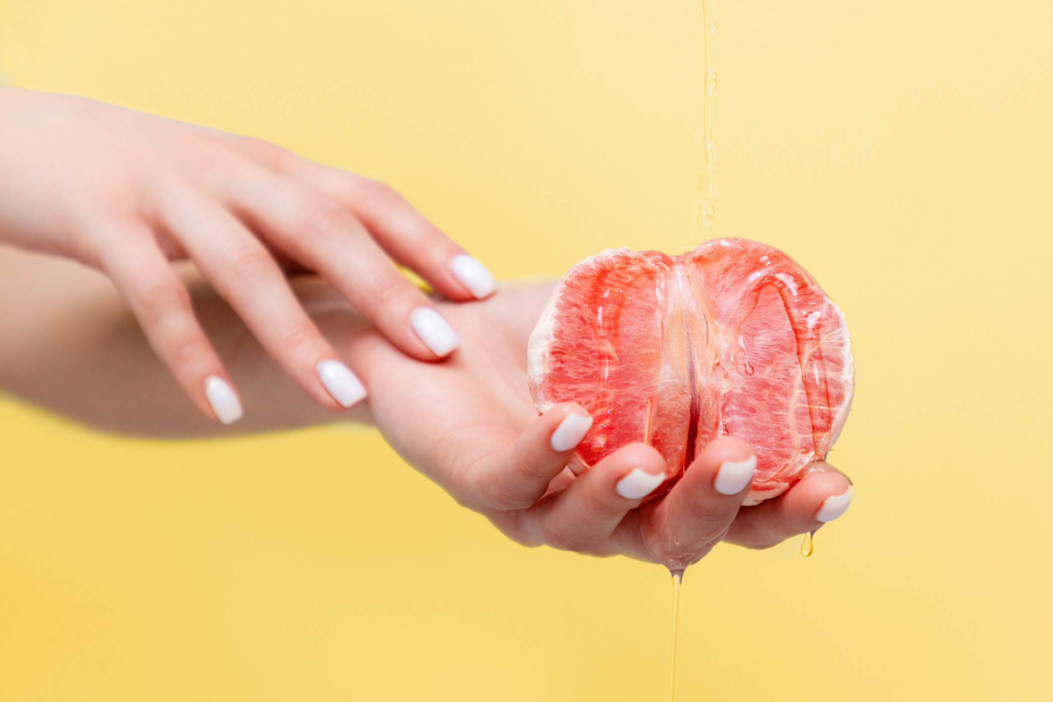 A person holding a peeled cut grapefruit