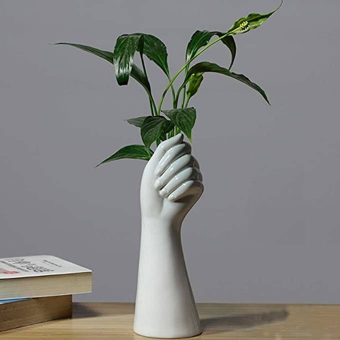 the vase with plants in it on a table in a room
