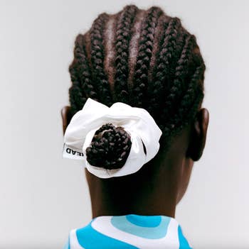 Model wearing white scrunchie in their hair