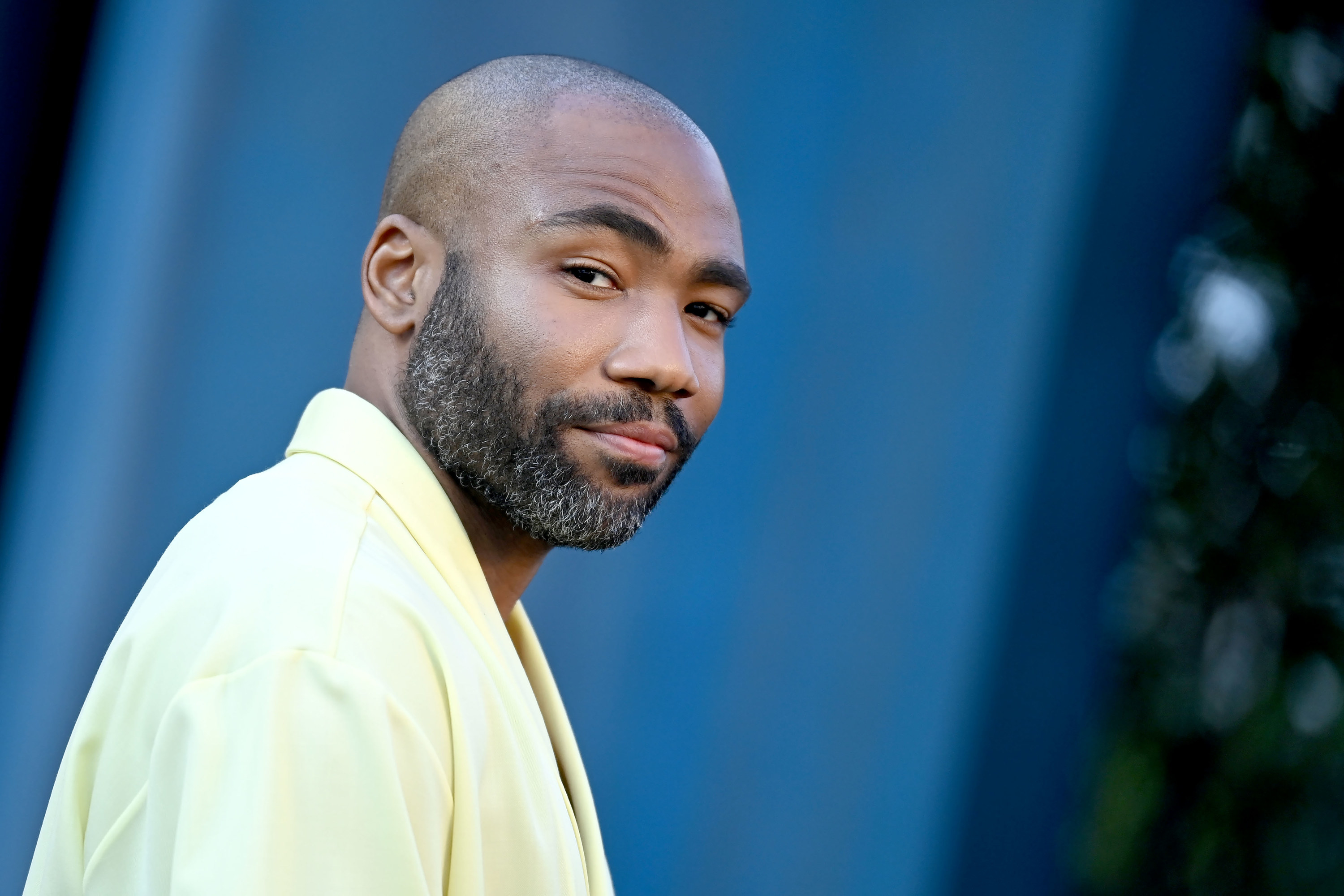 A closeup of Donald Glover slightly smiling at an event