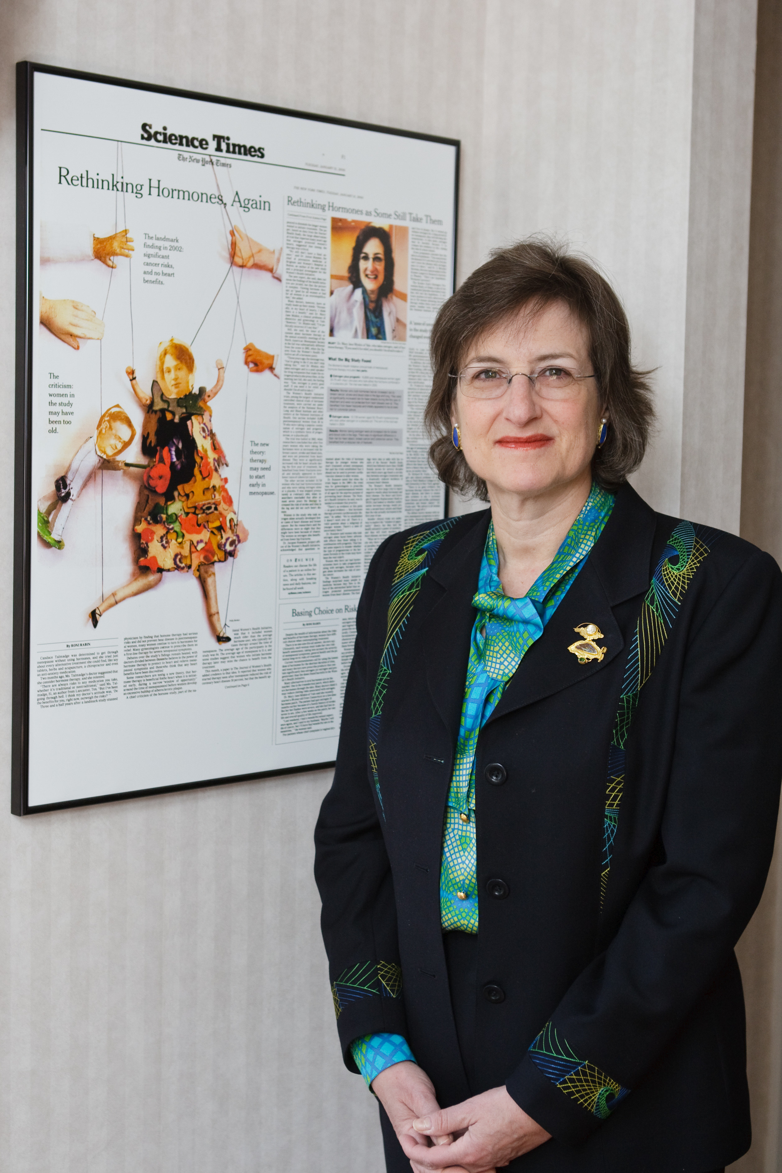 Dr. Minkin standing in front of a framed hanging photo of a New York Times Science Times article