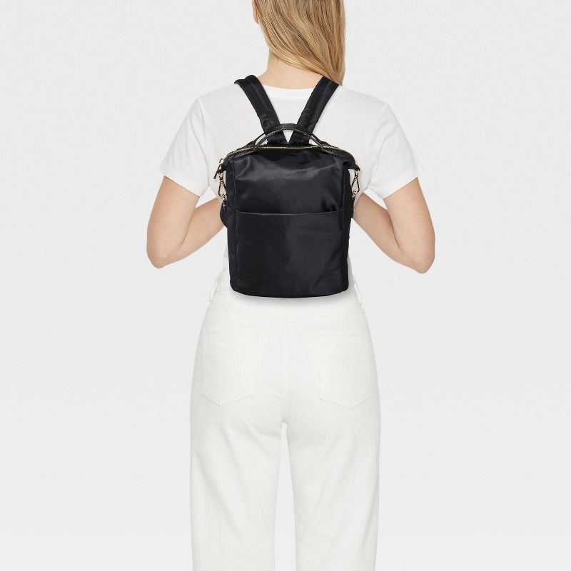 a model wearing the black backpack