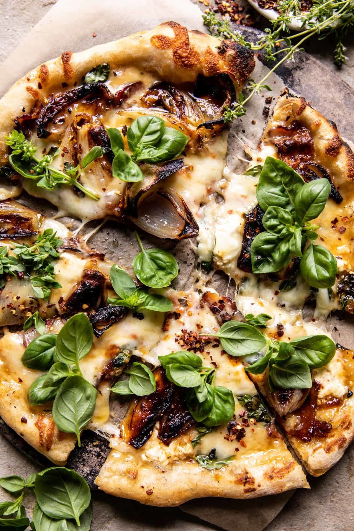A caramelized onion pizza with basil.