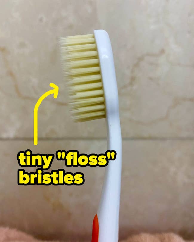 A toothbrush with two layers of bristles, one long and skinny and one shorter and thicker 