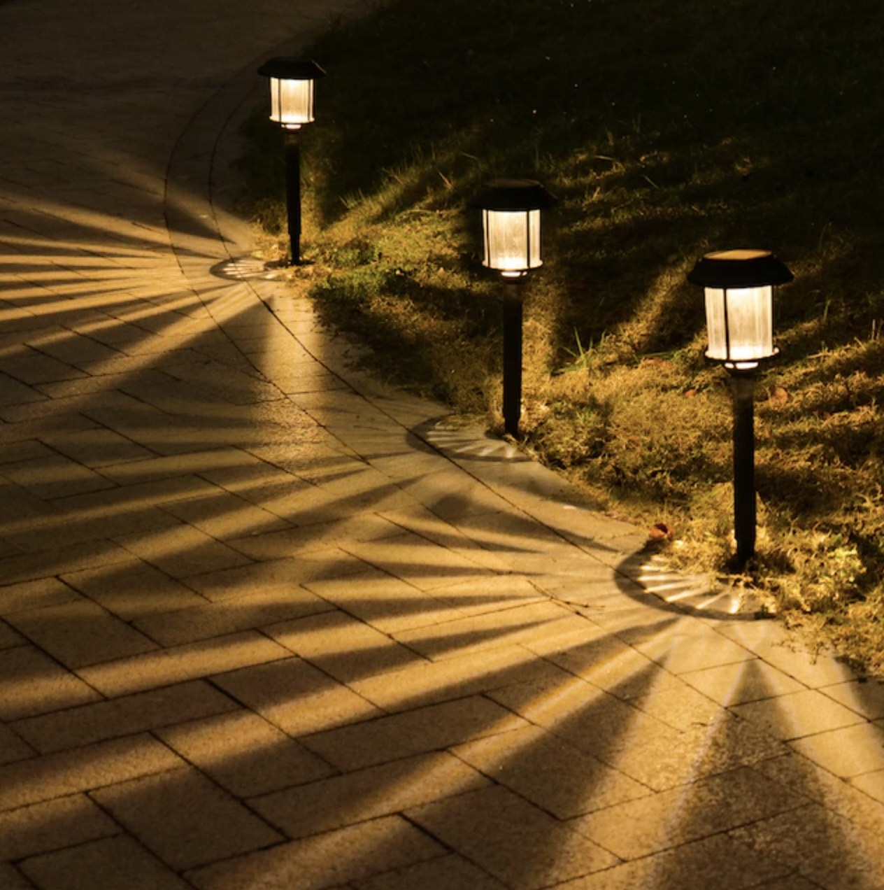 Three of the path lights glowing outside along front walkway