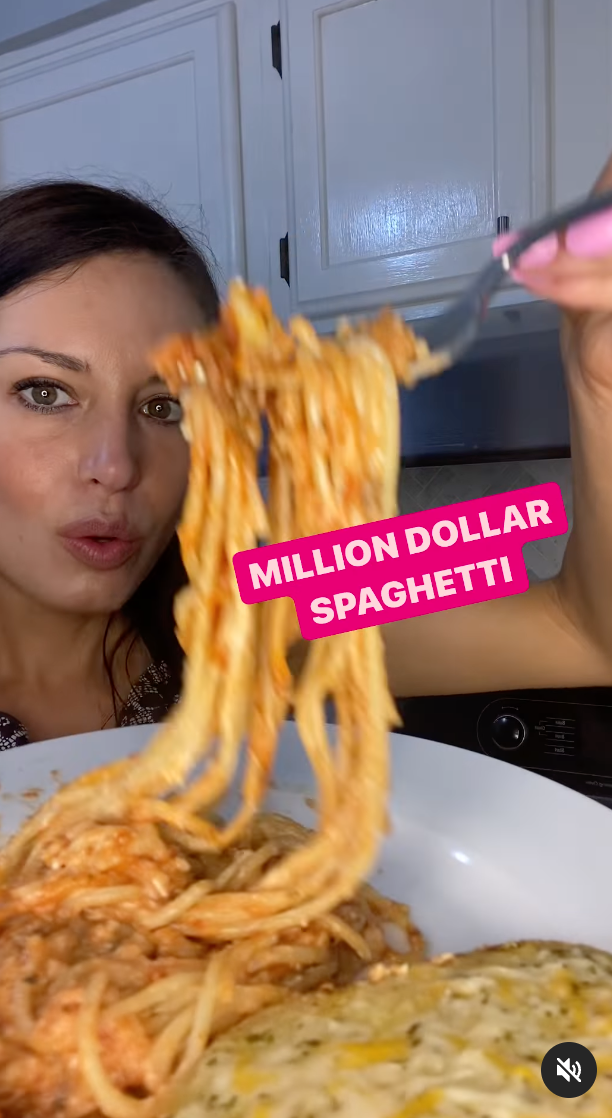 Woman holding up &quot;Million Dollar Spaghetti&quot; with fork