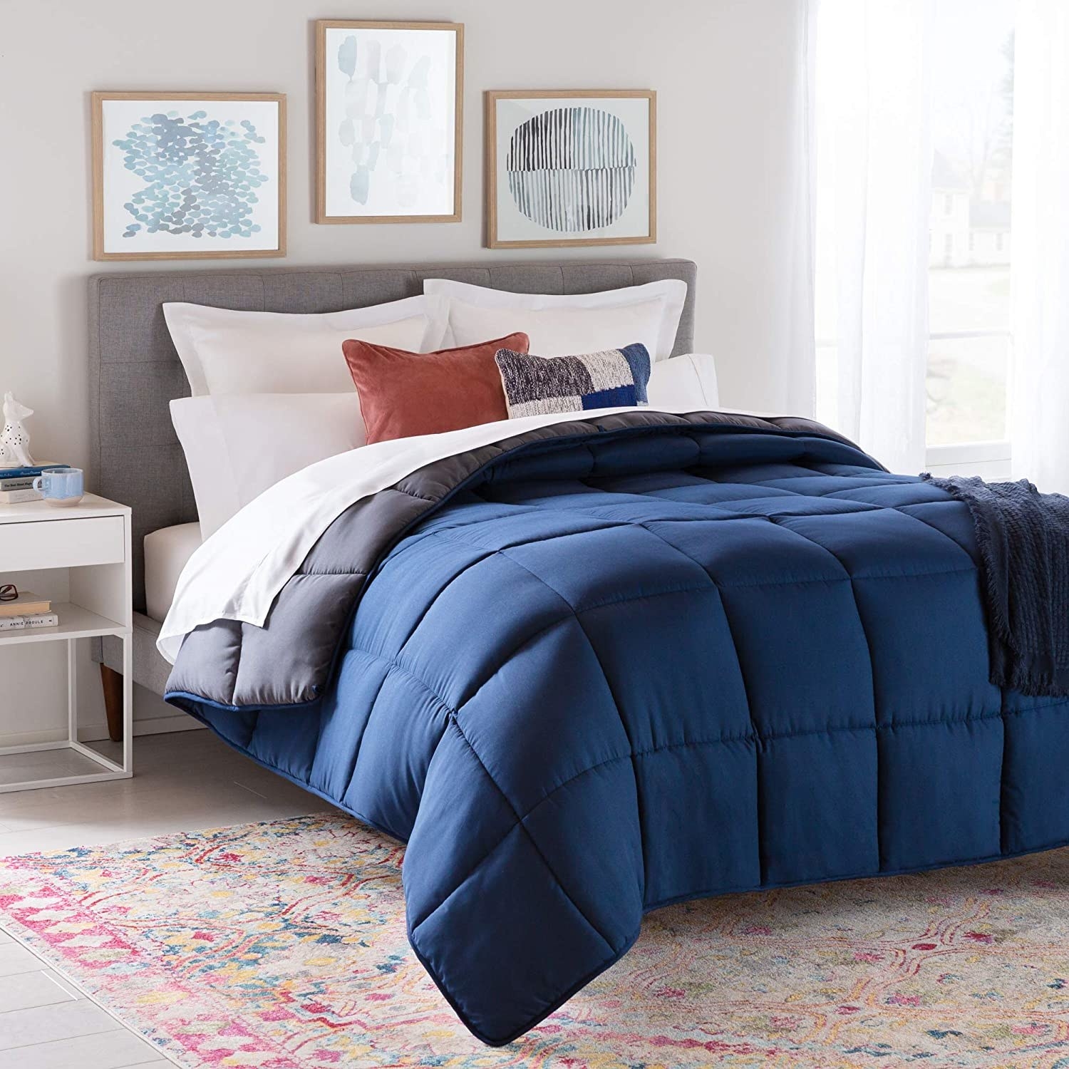 a comforter on a cozy bed in a stylish room