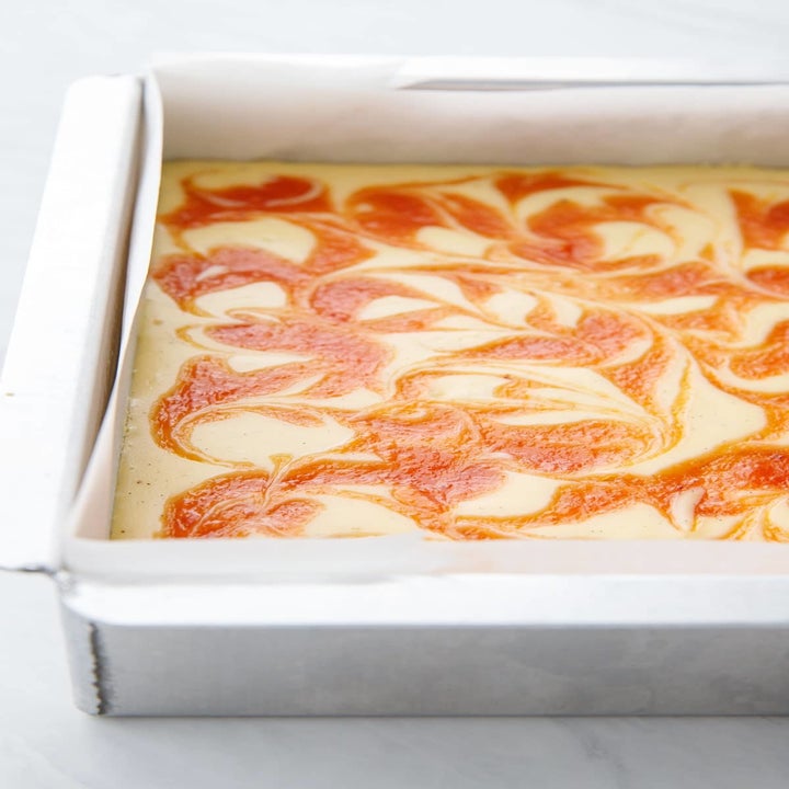 Peach cheesecake bars in a pan.
