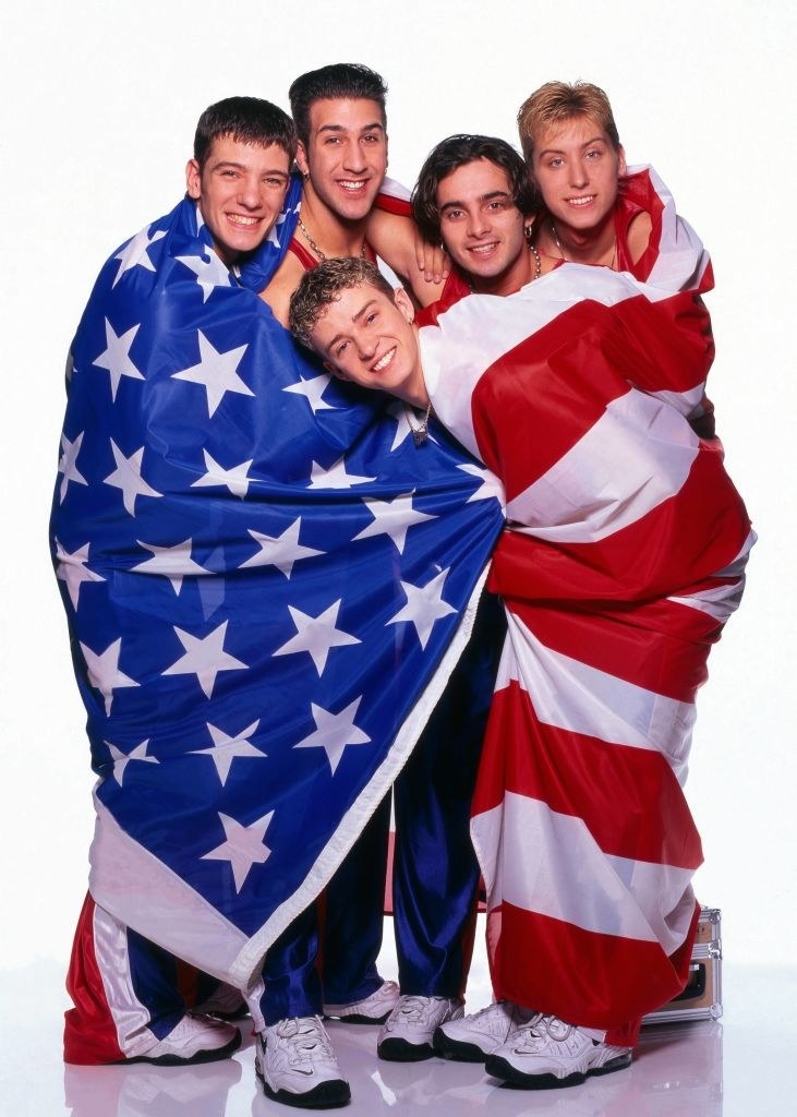 All the members of NSYN wrapped in a giant American flag