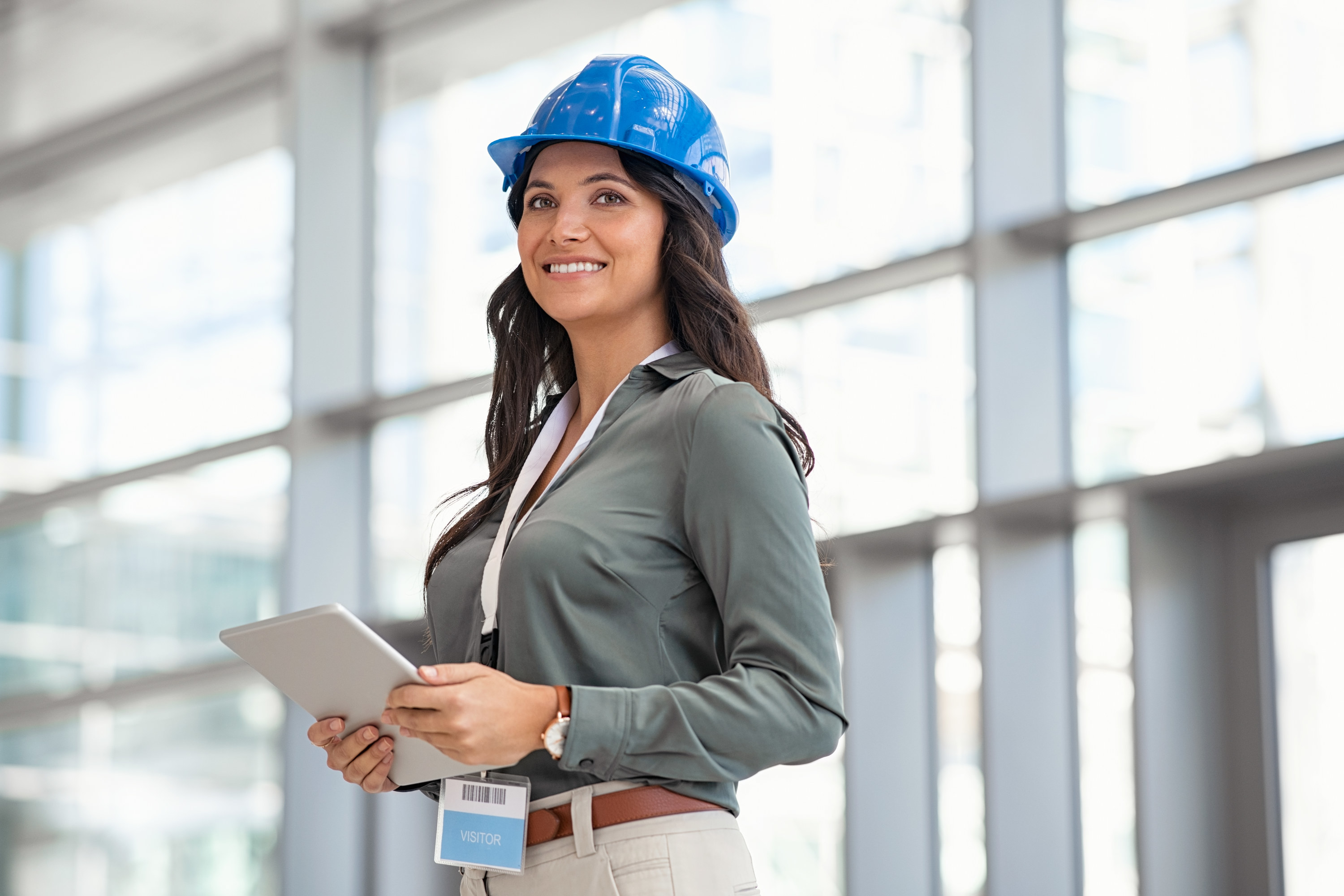 A woman with a safety hat on inside a building