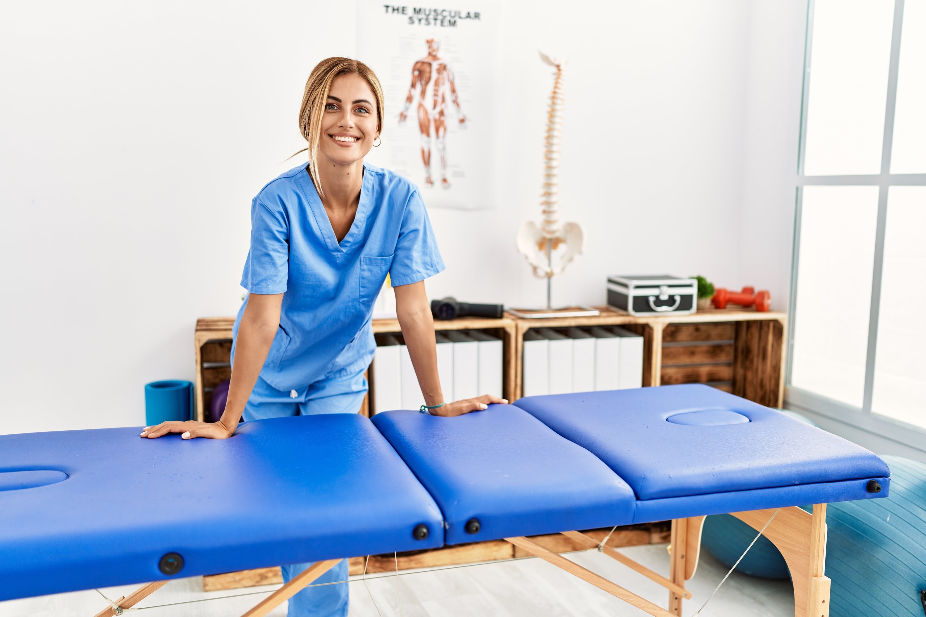 a massage therapist standing over a massage table