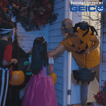 A man gives costumed kids candy for Halloween