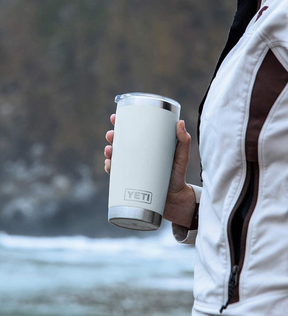 A person on a walk holding their yeti tumbler