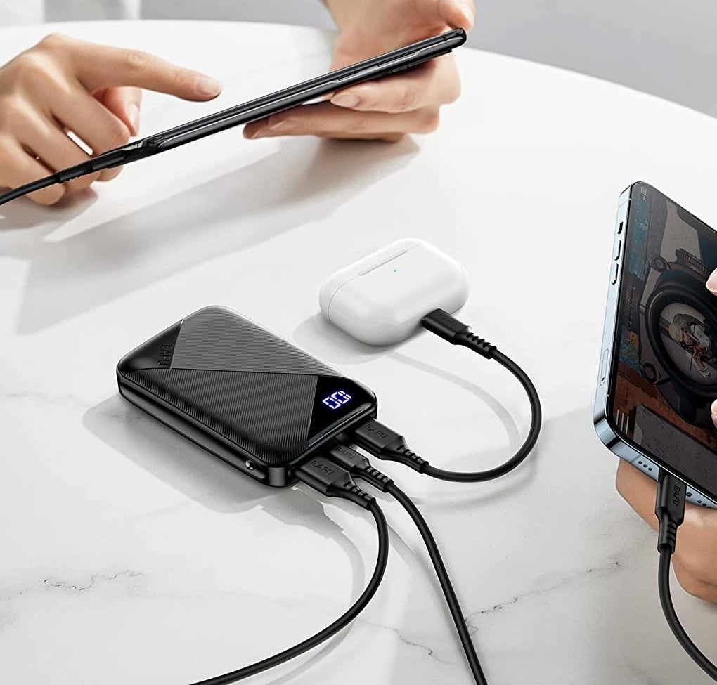The device on a table charging three different electronics