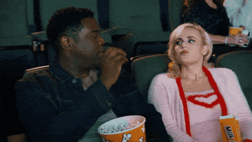 man tossing popcorn into his date&#x27;s mouth