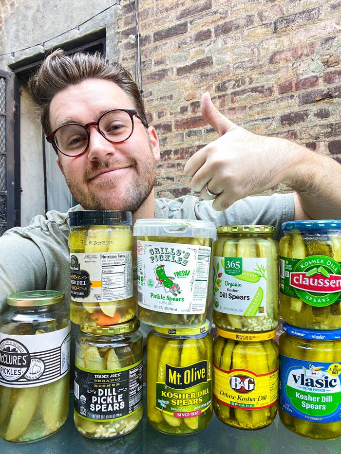 author behind a stack of jars of pickles