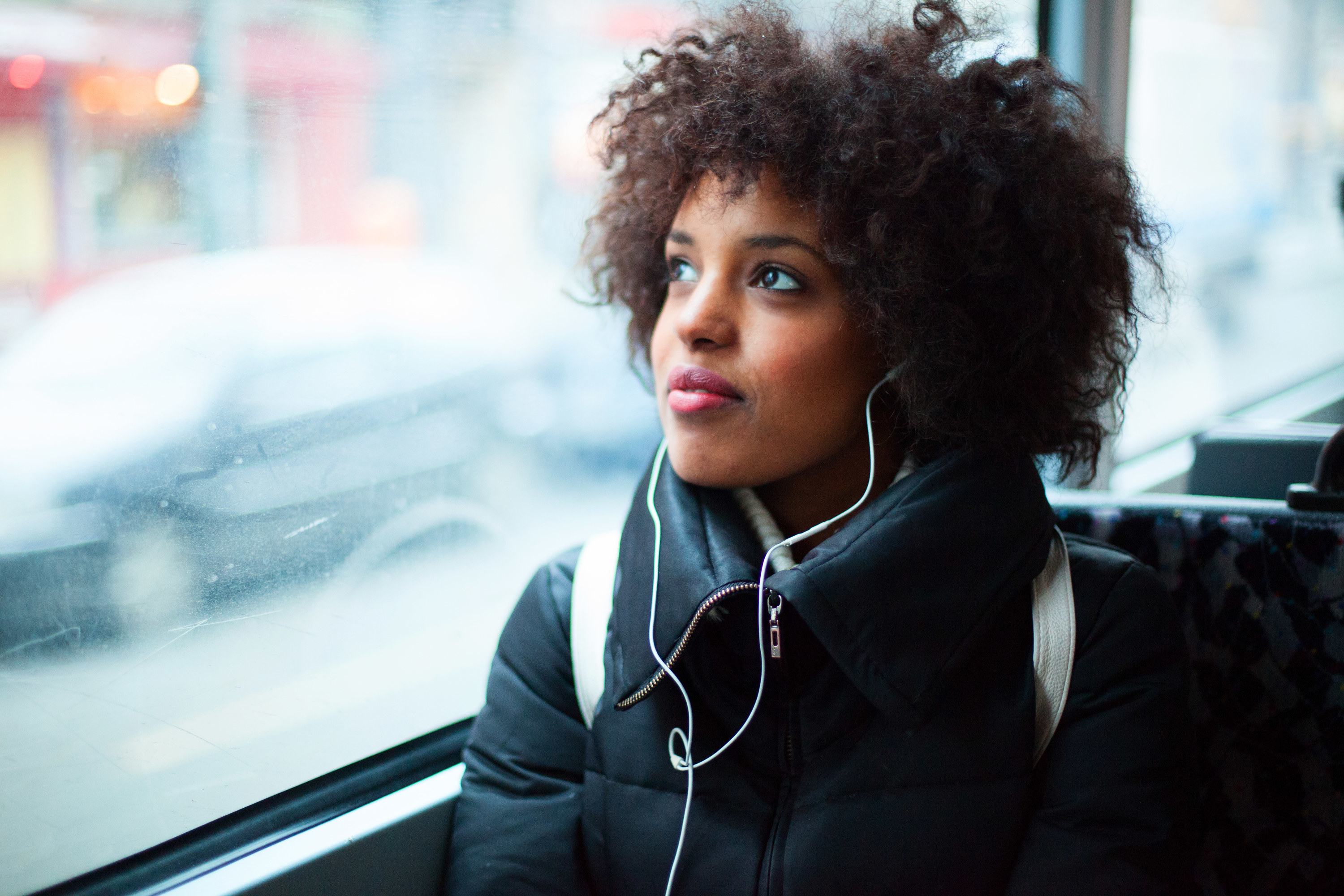 A woman listens to music while riding the bus