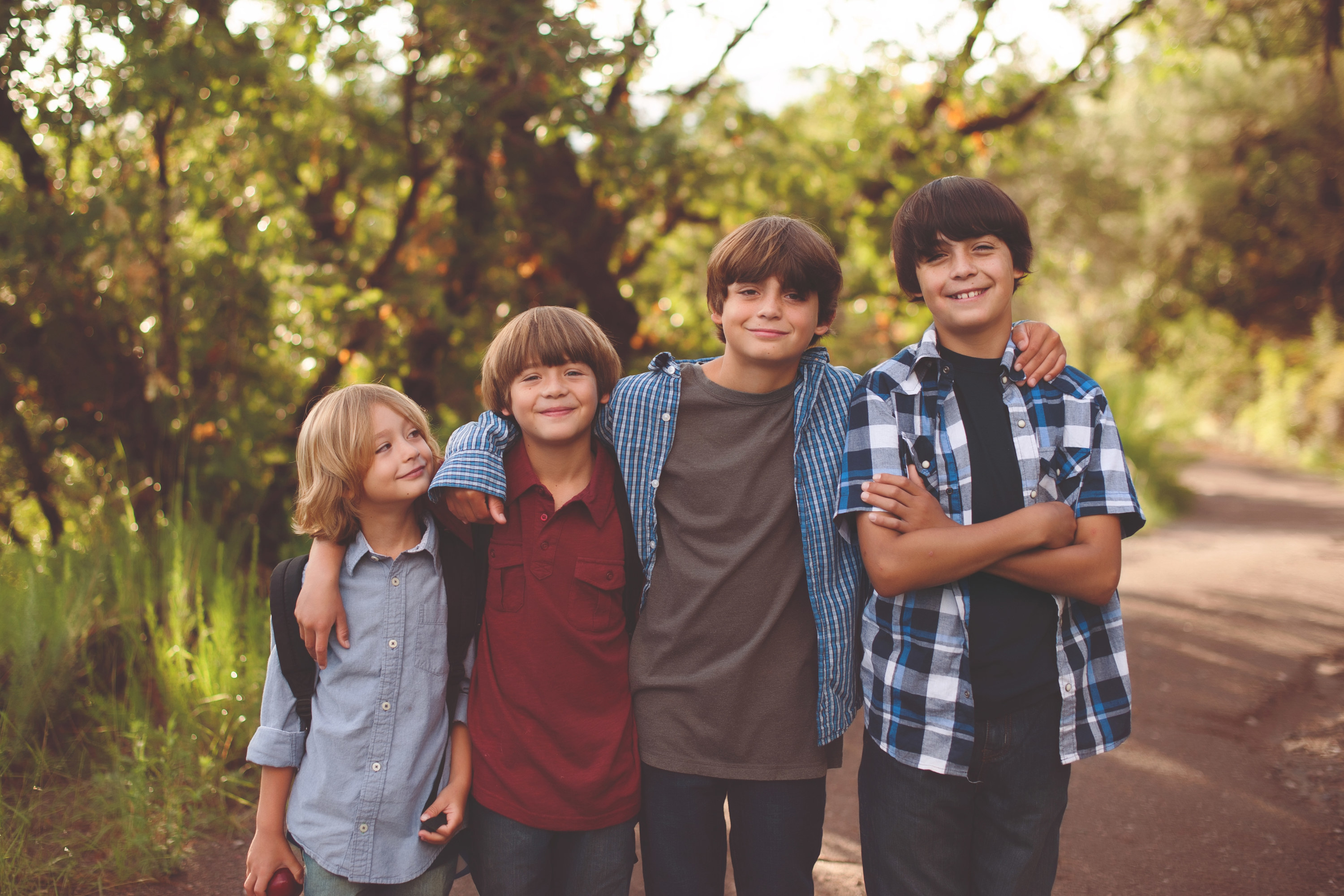Four brothers pose and smile on an outdoor trail