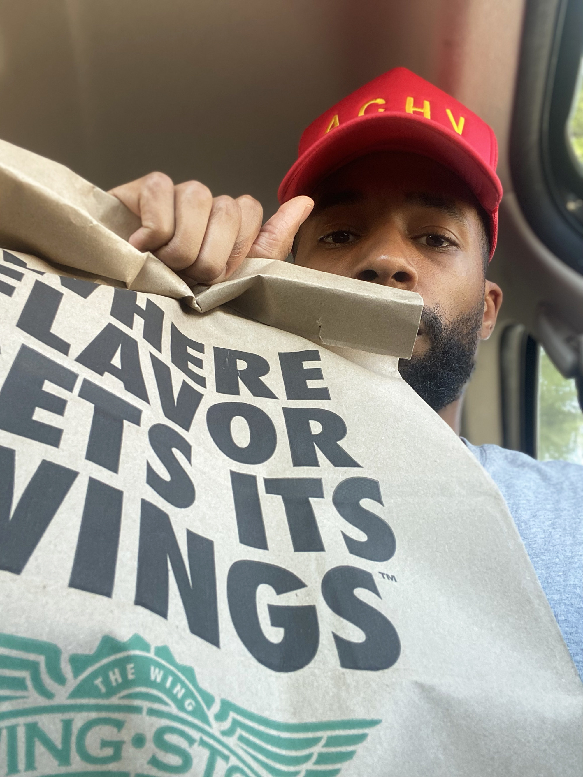 Christopher holding a Wingstop bag