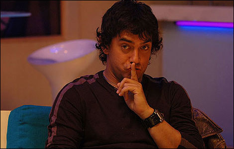 Aamir Khan from Rang De Basanti sitting on a couch with his left finger on his lips