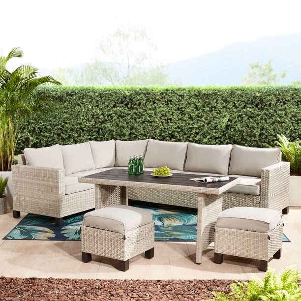 Beige wicker sectional with two ottomans and table